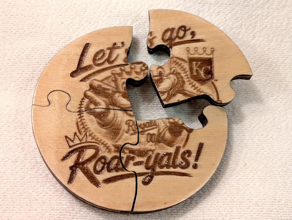 Four-piece engraved wooden puzzle coaster with one piece separated